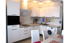 Красивая угловая глянцевая кухня "Gloss" с белыми крашеными фасадами и удобным пеналом